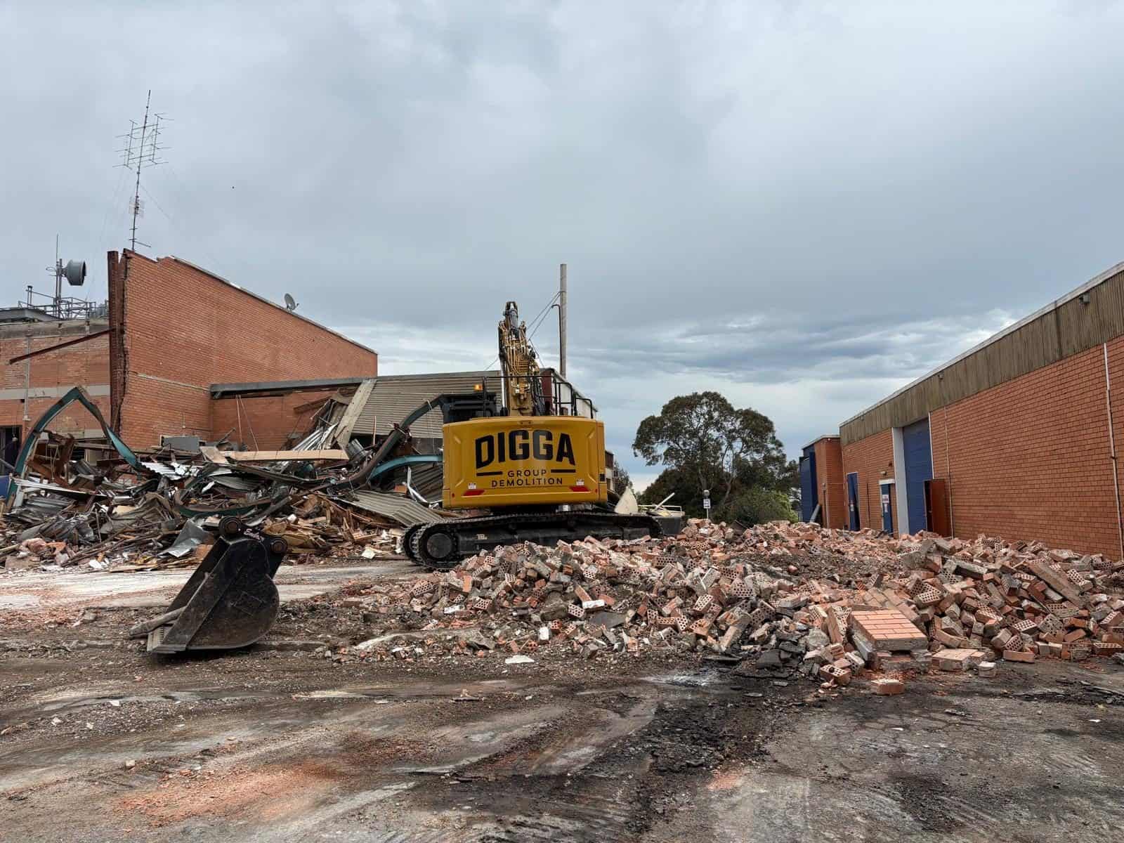 Digga Group excavator demolishing a brick studio building at the former WIN Studios site, Walker St Ballarat North